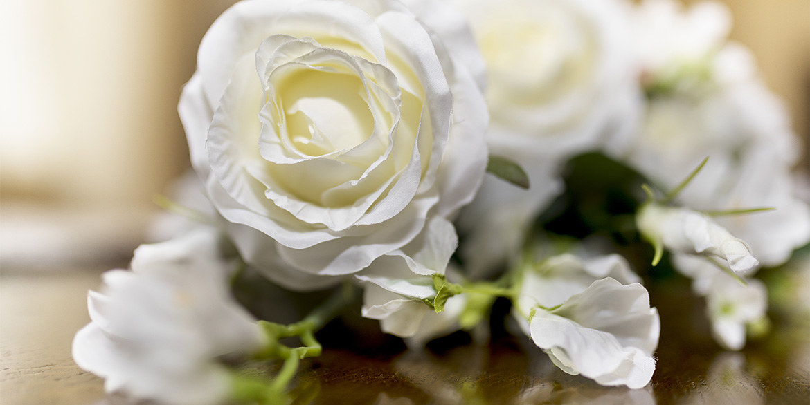 Primo piano di un mazzo di rose bianche adagiato su un tavolo